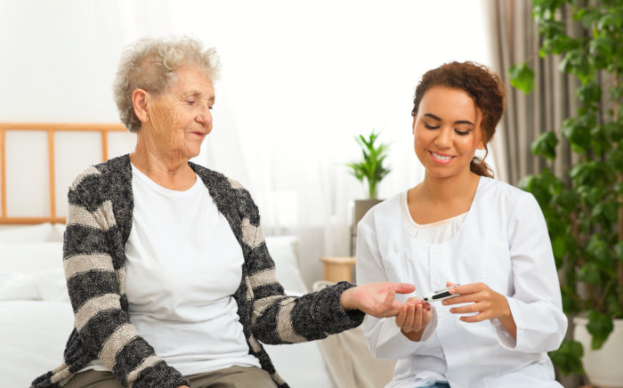 caregiver checking up an elderly woman